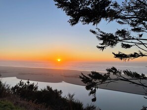 A sunset over a calm body of water with trees framing the view. - Garden Pond Retreat~Hot tub & Fire Pit! (Mckinleyville)