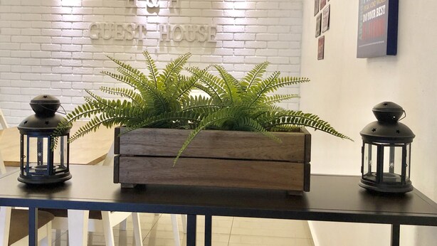 Un comptoir d’accueil avec une pancarte indiquant « Résidence » et une plante en pot.