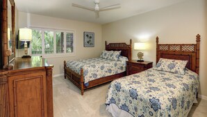 A bedroom with two wooden beds, a ceiling fan, and a window with blinds. - Amazing Remodeled Oceanfront Escape – Makena Surf F-202 with Spectacular Views! (Makena, Maui)