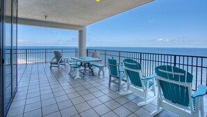A covered outdoor seating area with a view of the ocean. - The Oasis At Orange Beach 1911 by Liquid Life (Orange Beach)