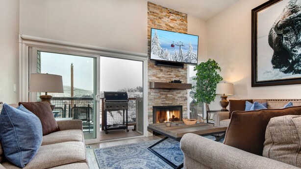 A modern living room with a fireplace, comfortable seating, and a television mounted above it. - Central Location, Perfect for Large Groups & Recreation! Park City Woodside Ski Estate (Ski-in/out) (Park City)
