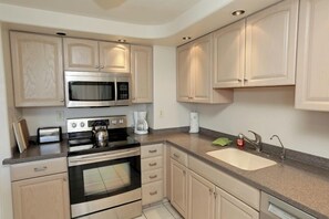 A modern kitchen with stainless steel appliances, a built-in oven, a microwave, and a sink.
