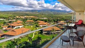 A balcony with a view of a residential area, including houses and greenery.