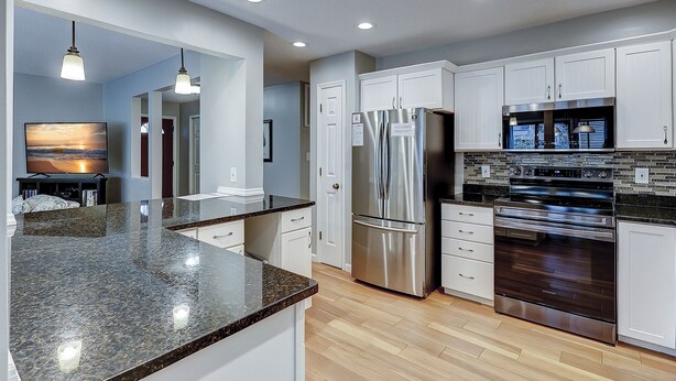 A modern kitchen with stainless steel appliances, white cabinetry, and a granite countertop. - 105 Beachwalk – Pet-Friendly Comfort Just Steps from the Beach (Hilton Head Island)