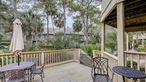 An outdoor deck with a wooden railing, metal tables and chairs, and a covered area with a pergola. - 105 Beachwalk – Pet-Friendly Comfort Just Steps from the Beach (Hilton Head Island)