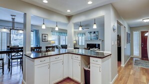 A kitchen with white cabinets, a granite countertop, and pendant lighting. - 105 Beachwalk – Pet-Friendly Comfort Just Steps from the Beach (Hilton Head Island)