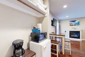 Cozy living space with a kitchenette, dining area, and fireplace.