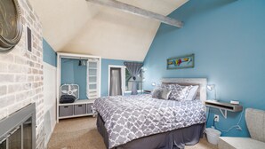 A bedroom with a bed, a nightstand, a dresser, a mirror, and a window with curtains.