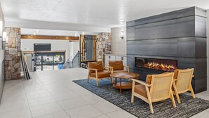 A spacious living area with a fireplace, seating, and a view of the garage. - Newly Renovated with Immaculate Updates. Winter Ski In/Out. TE102 (Breckenridge)