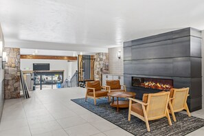 A spacious living area with a fireplace, seating, and a view of the garage.