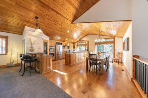 A spacious kitchen with wooden cabinets, a dining area with a table and chairs, and a large island.