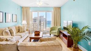 A living room with a sofa, armchairs, a coffee table, a TV, and a plant. - 🏖️Ariel Dunes I 1502 | 3BR • Pools • Gulf View • Seascape Beach🏖️ (Miramar Beach)