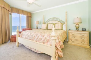 A bedroom with a bed, bedside tables, a dresser, and a view of the ocean. - Updated Modern Beachfront Condo w/ Stunning Gulf Views in Destin! 🌴☀🌊 (Destin)