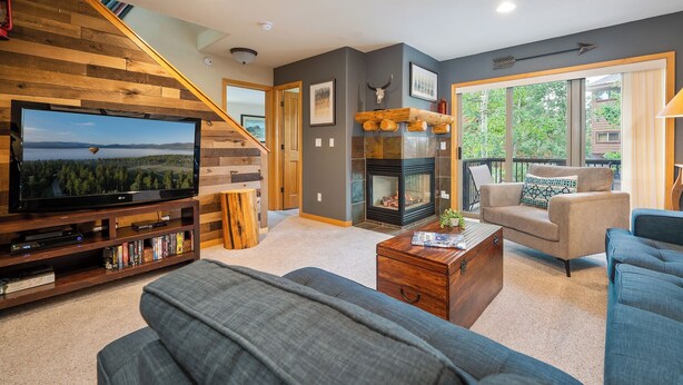 A modern living room with a television, fireplace, and comfortable seating. - Sawmill Station 220 | Private Hot Tub | Walk To Shops & Dining (Winter Park)
