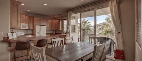 A kitchen with wooden cabinets, a dining table, and chairs.
