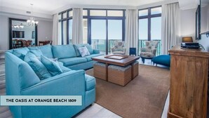 Ein geräumiges Wohnzimmer mit einer großen Couch, einem Couchtisch und Blick auf den Balkon.
