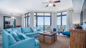 Un salon spacieux avec un grand canapé, une table basse et une vue sur le balcon.