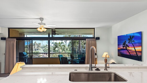 Una cocina moderna con un ventanal grande, un ventilador de techo y vistas al exterior.
