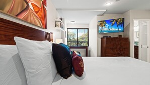 Una habitación de hotel con una cama grande, un televisor y una ventana con persianas.