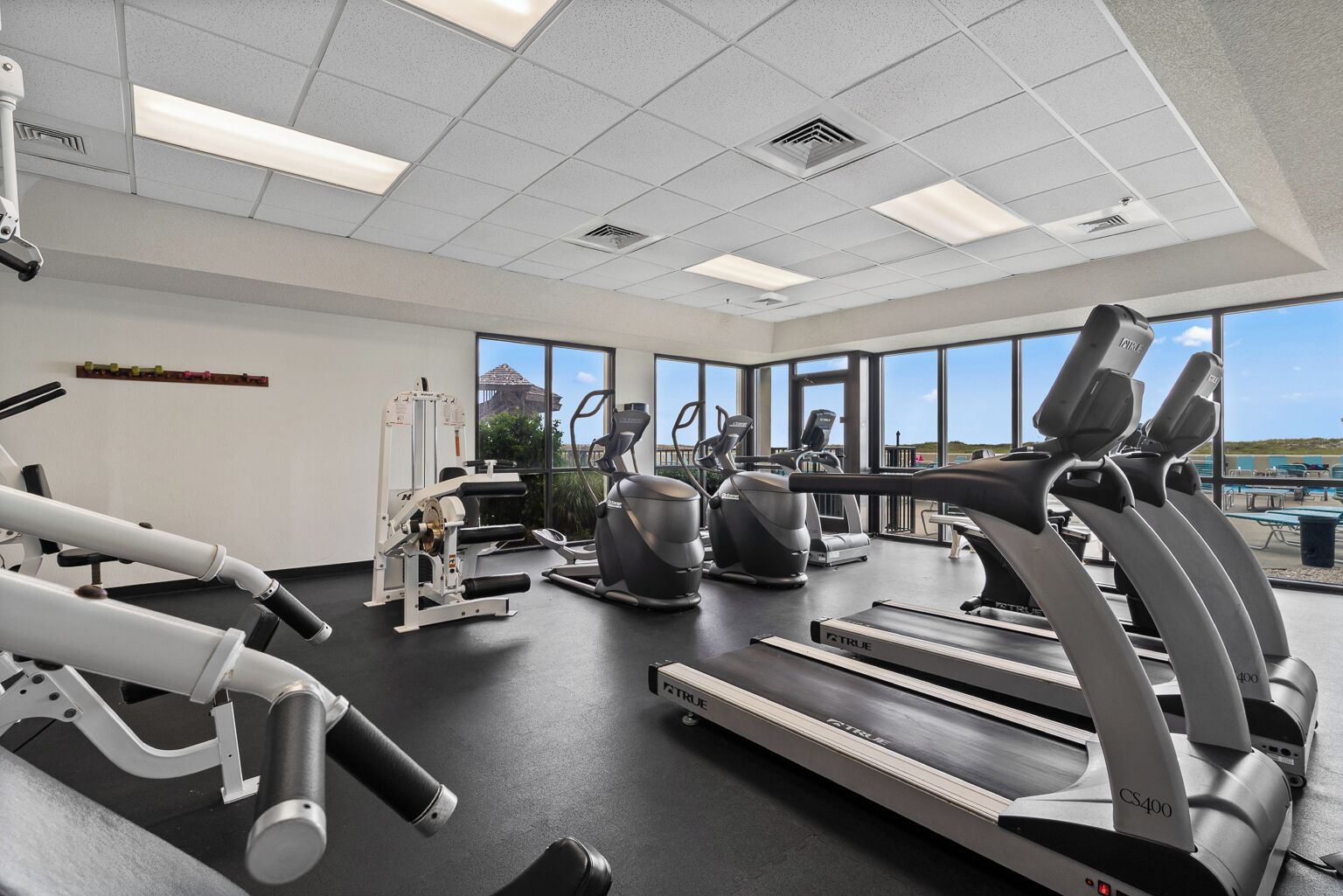 Et fitnesscenter med løbebånd, crosstrainere og træningsudstyr.