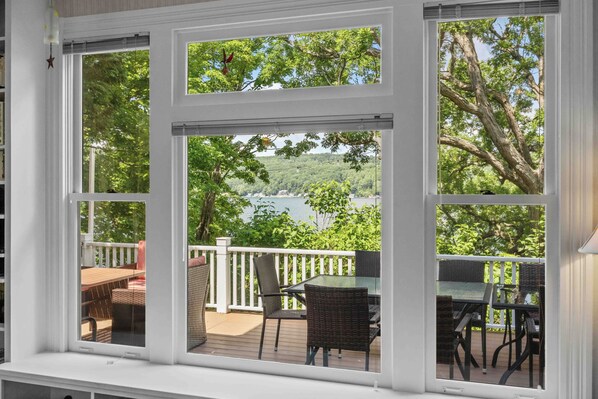 A view from a window with a deck, overlooking a lake and trees. - Great Adventure: Family Fun Starts Here! (Keuka Park)