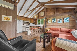 Een knus interieur met een keuken, eethoek en zithoek.