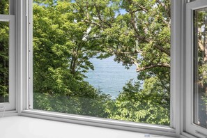A window with a view of a lake surrounded by trees. - Great Adventure: Family Fun Starts Here! (Keuka Park)