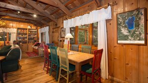 Interior de una cabaña de madera con una mesa de comedor, sillas y un mapa del lago Tahoe en la pared.