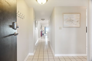 Stylish hallway with a door, framed picture, and window leading to a room.