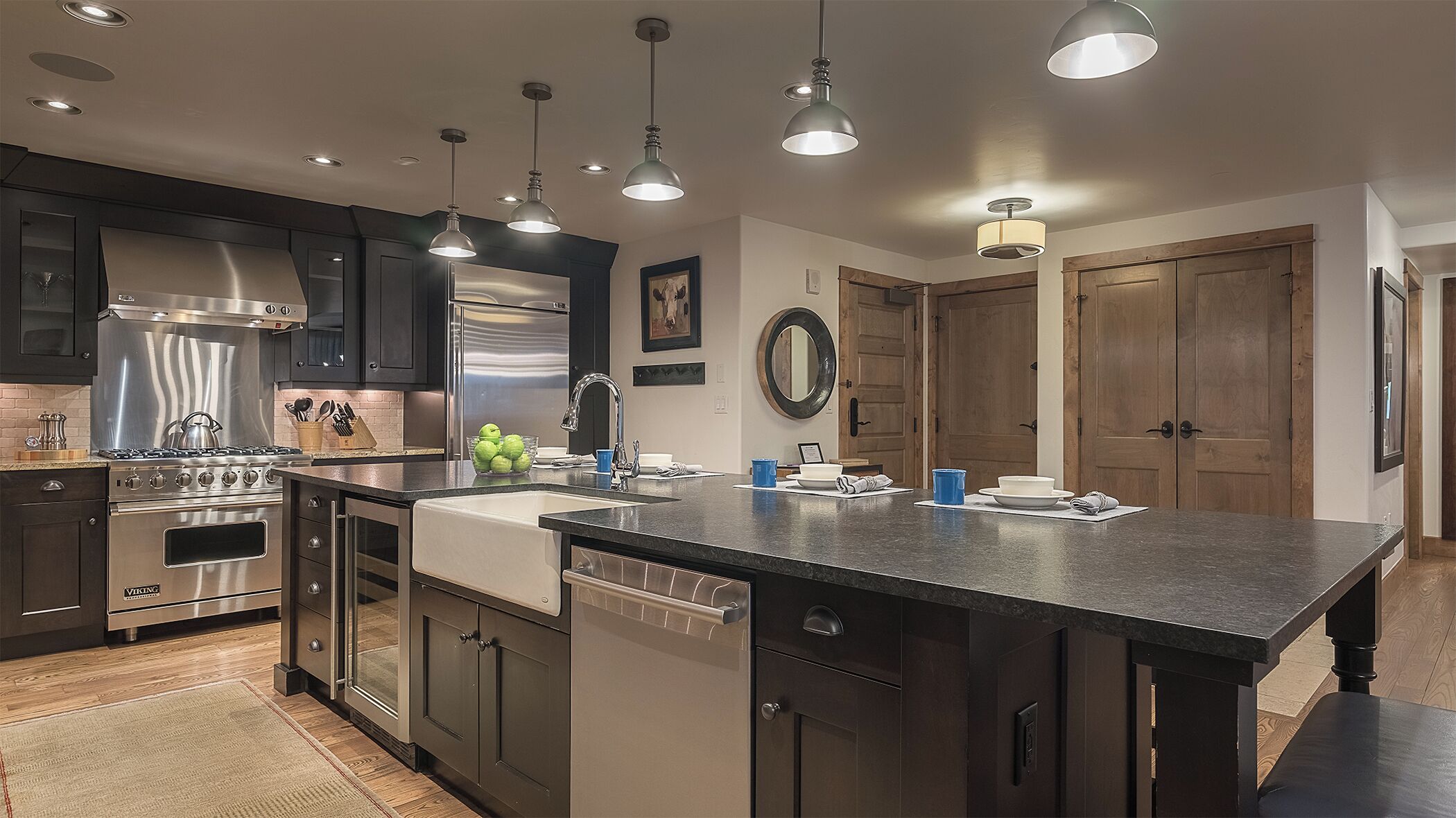 A modern kitchen with a central island, stainless steel appliances, and pendant lighting.