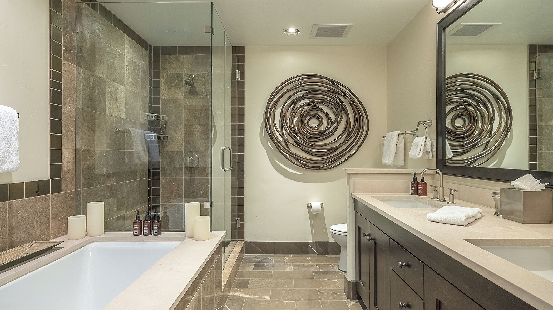 A modern bathroom with a glass-enclosed shower, a bathtub, and a vanity with a mirror.