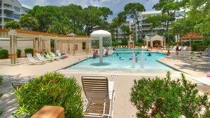 A swimming pool area with lounge chairs, a water fountain, and a covered seating area. - 2315 Windsor II -Beautiful Oceanfront 1 Bedroom Villa! (Hilton Head Island)