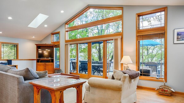 A spacious living room with a large window, a television, and a dining area.