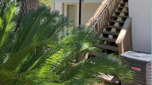 A two-story building with a wooden staircase and a balcony.