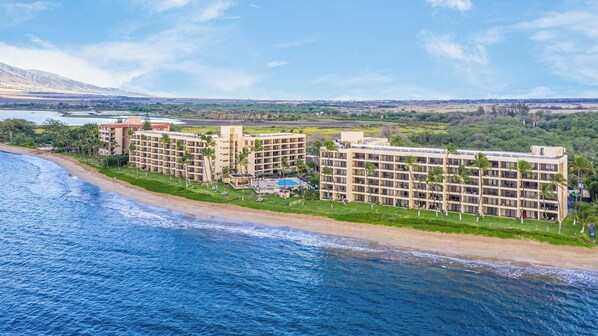 Ein Strandhotel mit mehreren Gebäuden, einem Swimmingpool und direktem Zugang zum Strand.