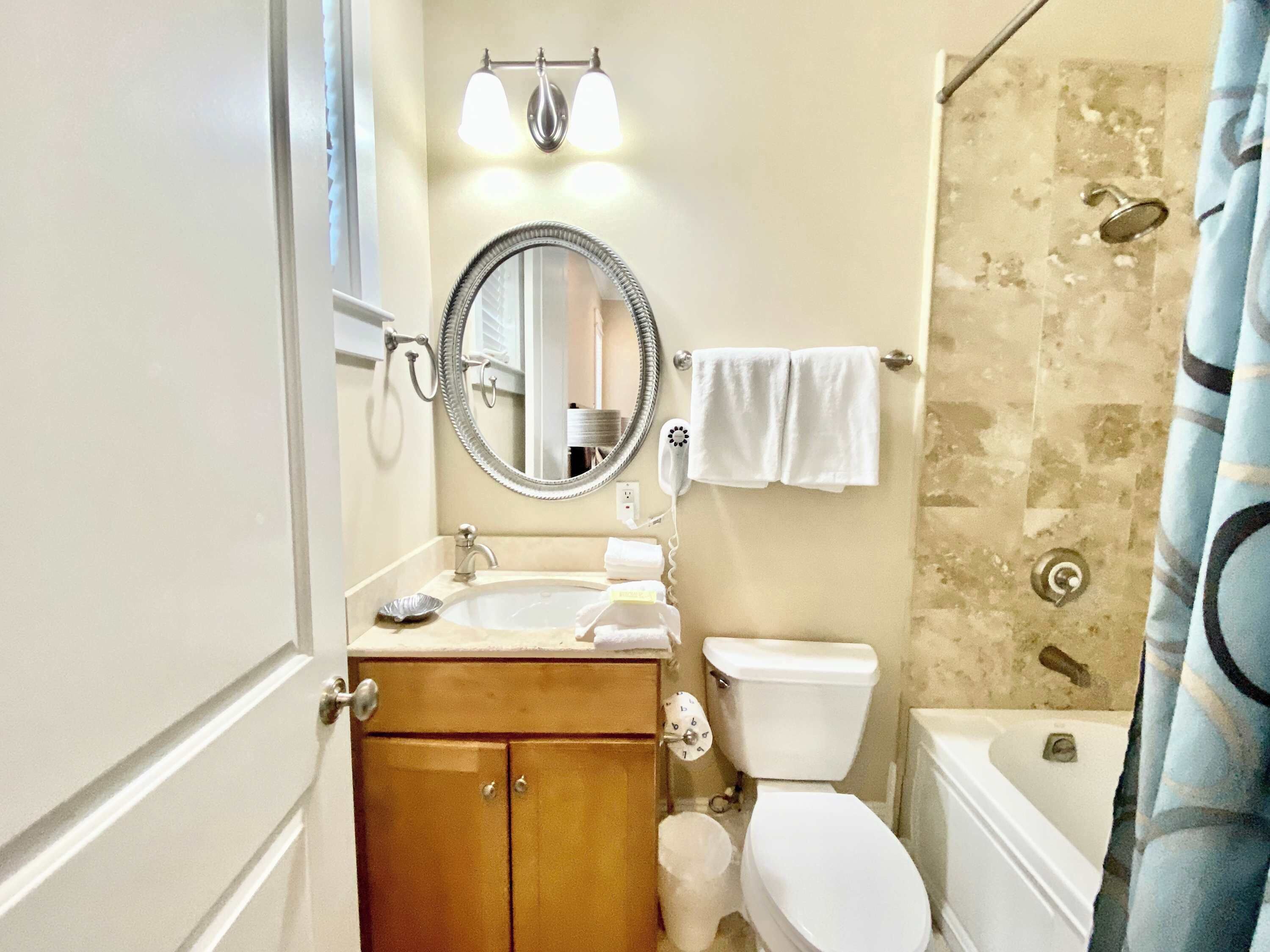Un baño con lavamanos, espejo, inodoro y ducha.