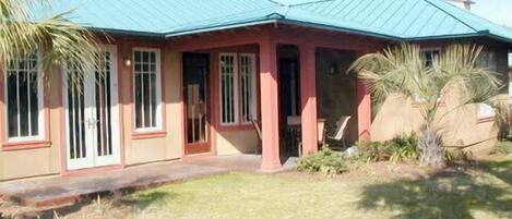 A single-story house with a red exterior and a blue roof.