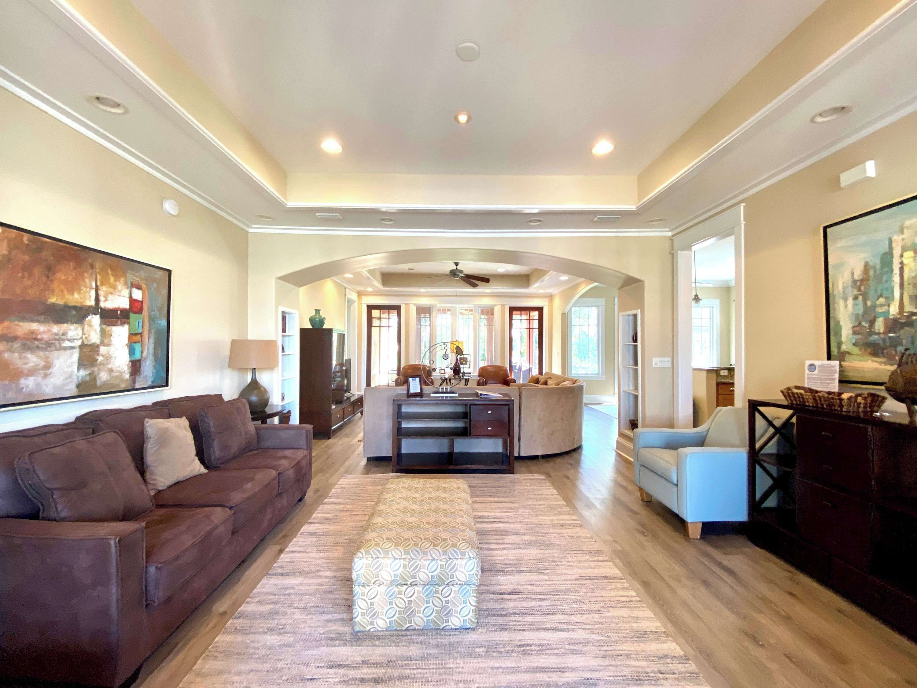 A spacious living room with a large sofa, a coffee table, and a patterned rug.