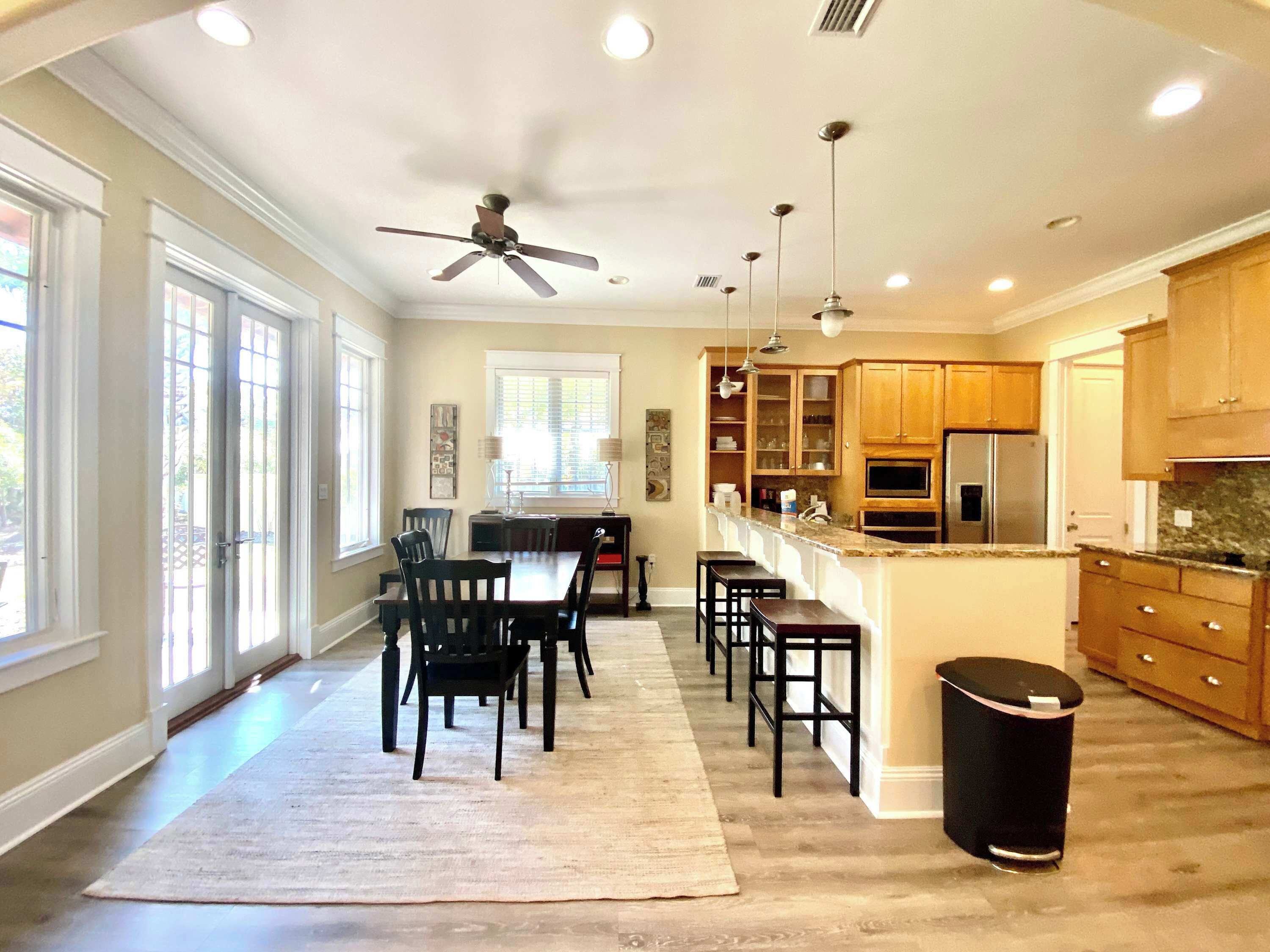 A spacious kitchen with wooden cabinets, a central island, and a ceiling fan.