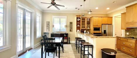 A spacious kitchen with wooden cabinets, a central island, and a ceiling fan.