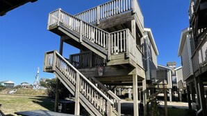 Una terrazza in legno a più livelli con ringhiere, un tavolo da picnic e un cestino.
