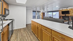 A modern kitchen with wooden cabinets, a white countertop, and a built-in microwave. - Free SkyCard Activities - Budget, Walk to Town, Pool & Hot Tubs - The Lift C112 (Breckenridge)