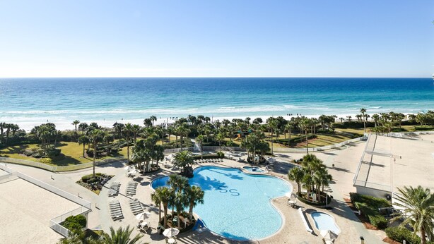 A resort with a large pool, palm trees, and a view of the ocean. - Open-concept beachfront condo w/ beach service included at Silver Shells! 🌴❤ (Destin)