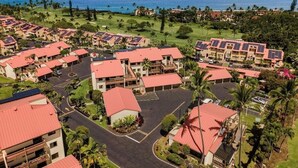 Et resort med flere bygninger, en parkeringsplads og havudsigt.