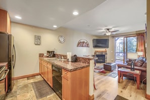 A modern kitchen with granite countertops, wooden cabinets, and a built-in dishwasher. - Free SkyCard Activities - Gas Fireplace, Parking, Equipped Kitchen, Fitness Ctr (Breckenridge)