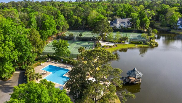 Una propiedad junto al lago con varias canchas de tenis, piscina y un pabellón.
