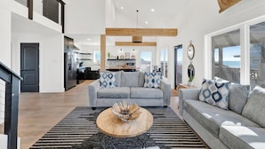 A spacious living area with a grey sofa, a wooden coffee table, and a black and white striped rug. - Gulf Front | Pet Friendly | Shared Pool (Gulf Shores)