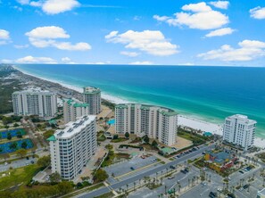 A high-rise hotel with multiple floors, a parking area, and a beach view. - Live the High Life: Luxe 11th Floor Gulf Front Condo Awaits Your Arrival! (Destin)