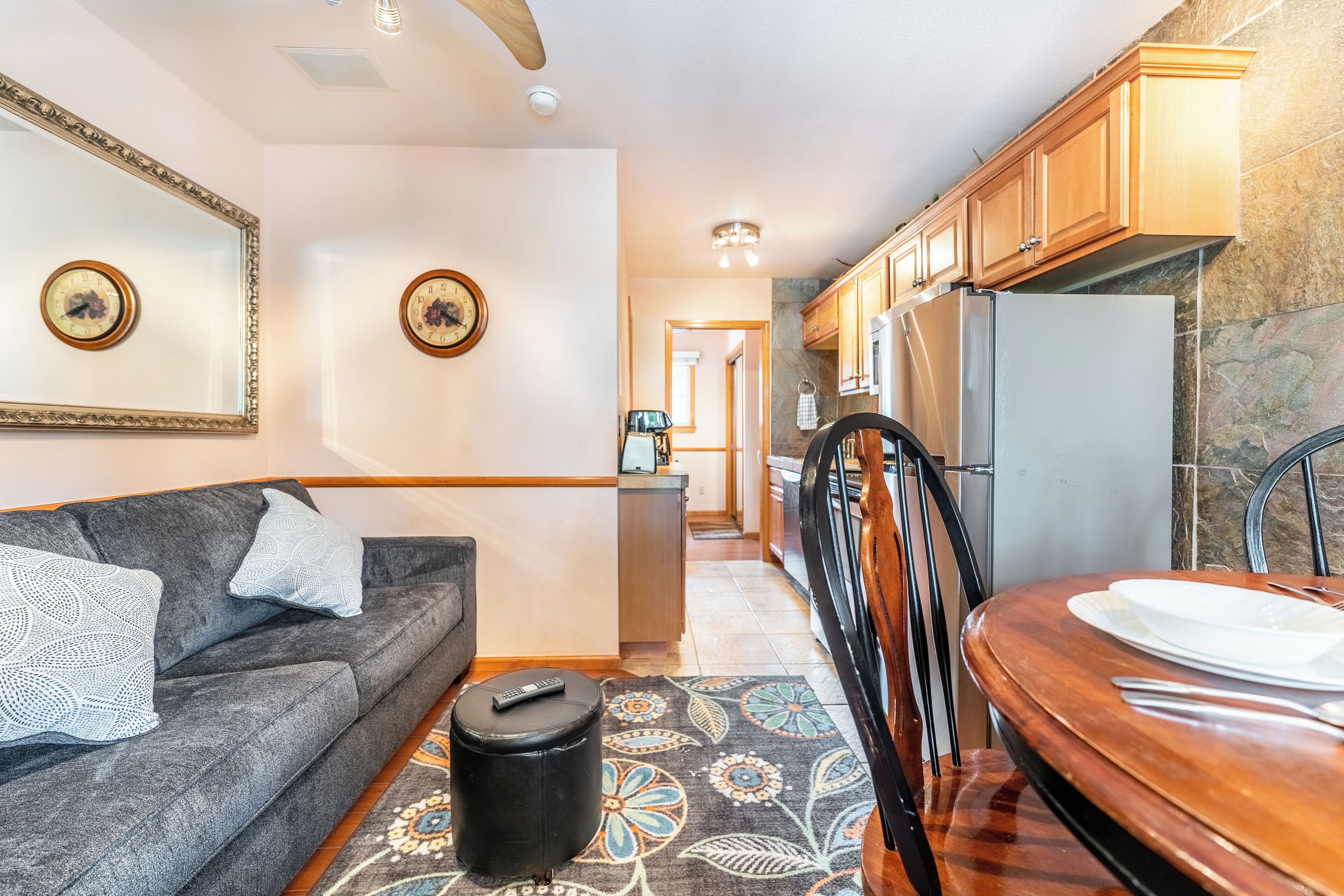 Un espacio habitable compacto con sofá, una mesa de comedor y una zona de cocina.