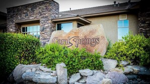 Un edificio con fachada de piedra y un letrero grande de roca que dice 'Coral Springs'.